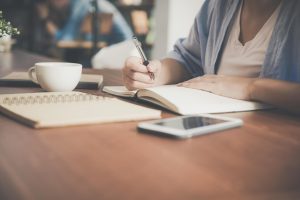 A person writing text on a book