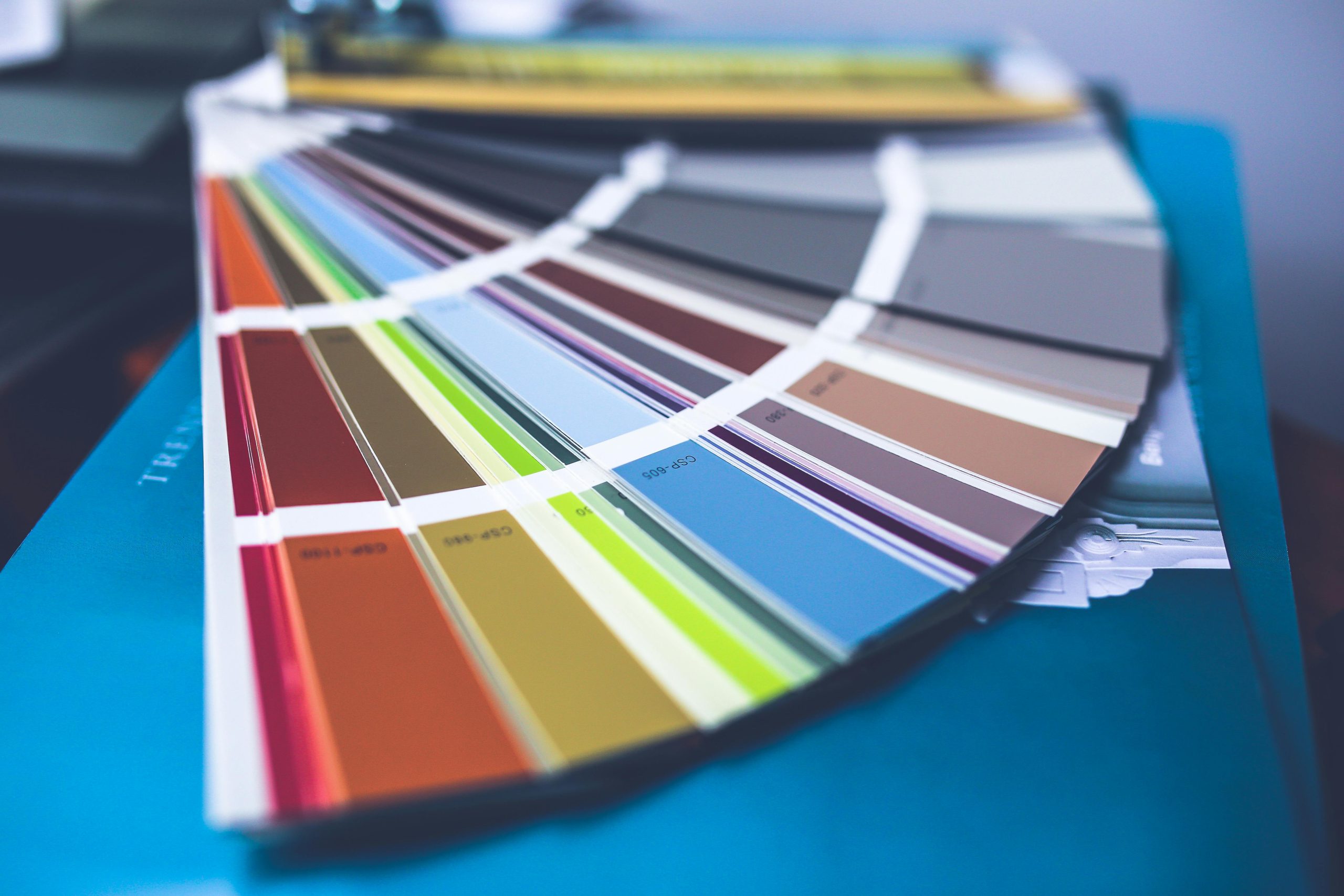 A collection of colorful paint swatches spread out showcasing a variety of hues
