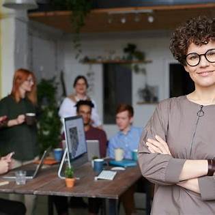Confident product manager leading a discussion with a diverse team in a modern office, emphasizing strategic collaboration and smart leadership